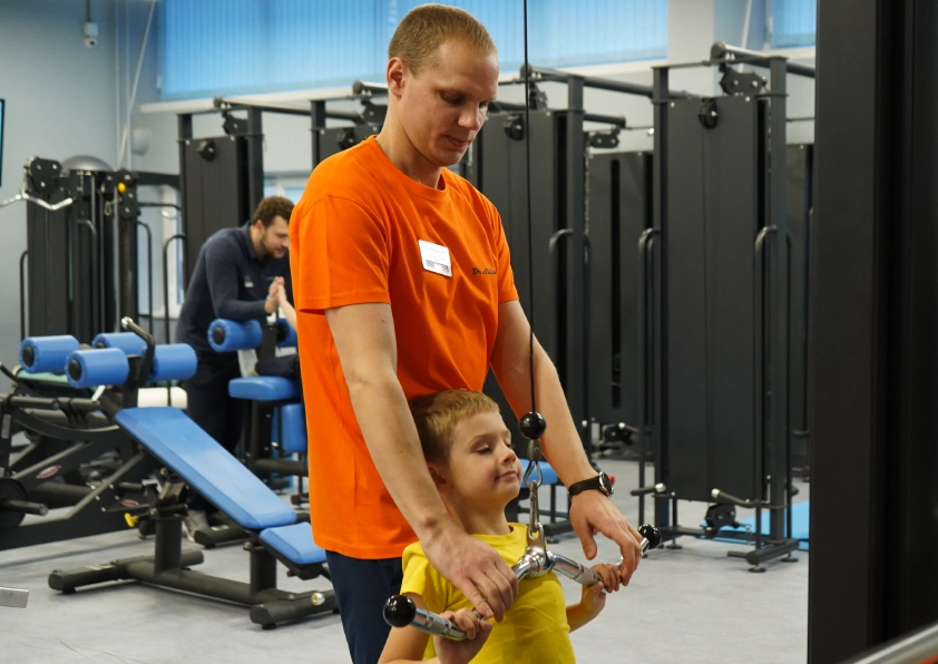 Фото инструктора и ребёнка на занятиях ЛФК при лечении РАС