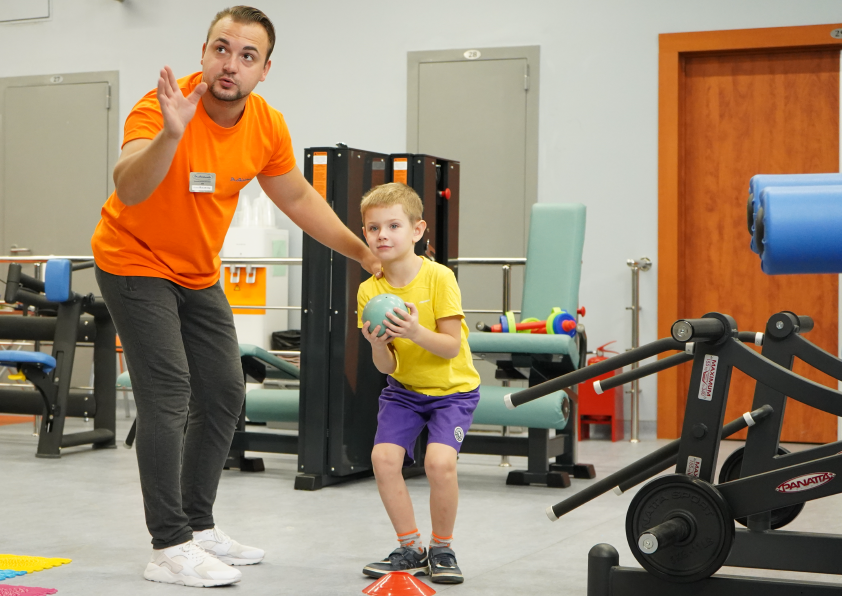 Фото инструктора и ребёнка во время выполнения упражнений при лечении РАС