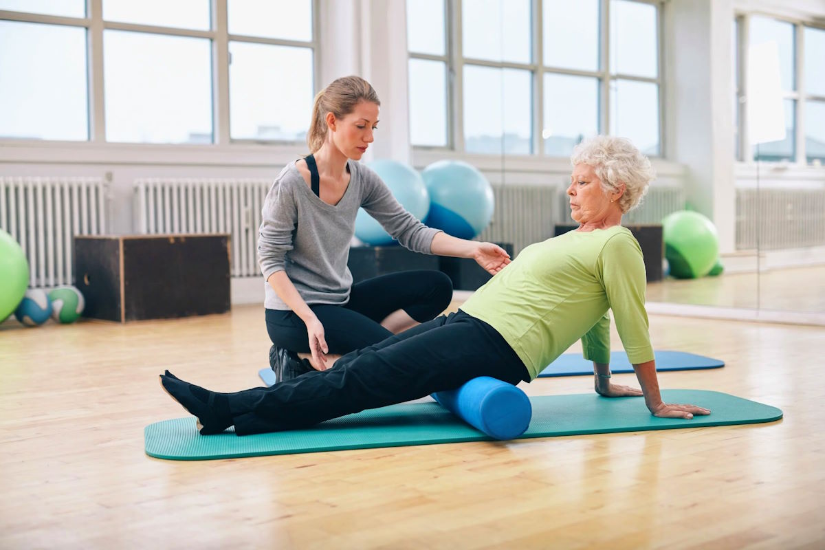 Женщина занимается ЛФК Женщина на занятии лечебной физкультурой